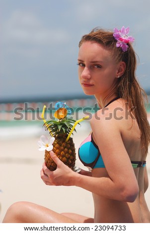 Girl with tropical cocktail on the beach