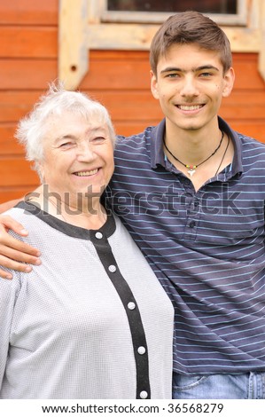 Happy grandmother and grandson in front of house