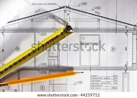 Pencil and tape meausure over house plan blueprints
