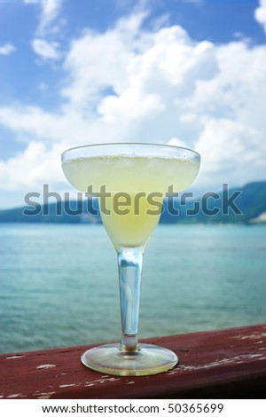 Margarita cocktail with sea and sky in background