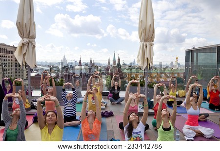 MOSCOW -MAY 31: Surya Namaskar (Sun Salutation) - public yoga classes on the roof of the Ritz-Carlton Hotel, Red Square background on  May 31, 2015 in Moscow, Russia