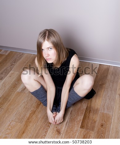 scared young woman sits on a floor
