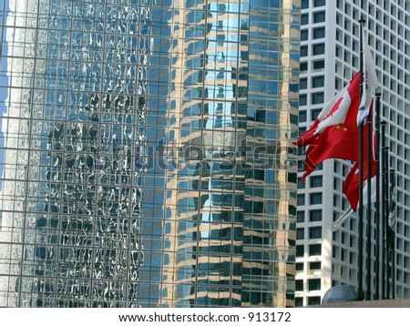 Flags of Canada, China and others reflecting in windows of Hong Kong\'s skyscrapers
