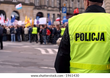 Police officer protecting an anti-government demonstration in Warsaw Poland on 7 October 2006 (Blue March by Platforma Obywatelska). Purposely taken with a shallow DOF not to detail faces.