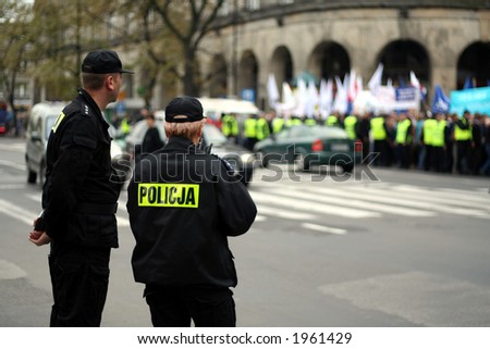 Two police officers during an anti-government demonstration in Warsaw Poland on 7 October 2006 (Blue March by Platforma Obywatelska). Purposely taken with a shallow DOF not to detail faces.