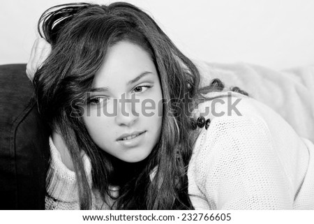 Black and white portrait of a young girl sitting on a couch