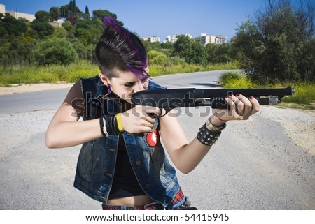 young punk girl with his gun in his hands and pointing to his left