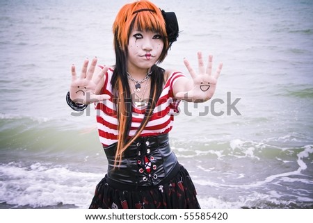 Asian girl dressed as a mime showing a happy face and a sad face