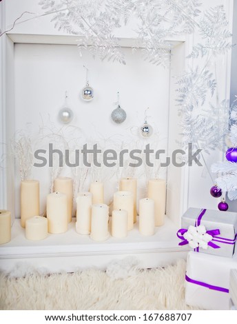 white candles and chimney with silver toys and silver branches