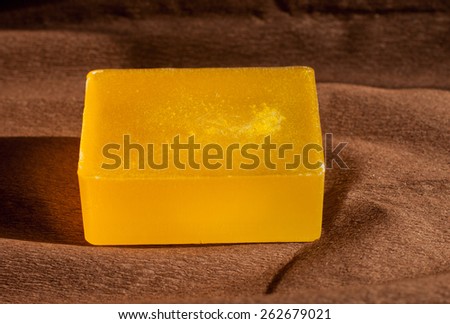 soap with sea-buckthorn oil on brown paper with sun shining rays