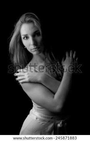 Ballerina with crossed arms, low key dramatic light in black and white