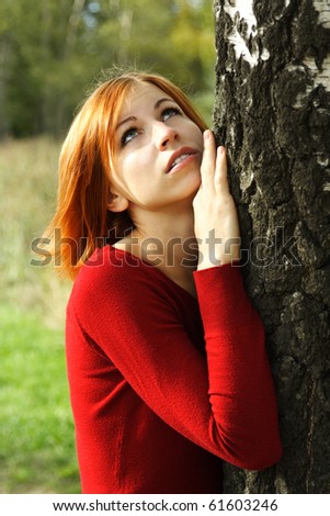 beauty girl in red dress snuggle up to tree, half body, looking up