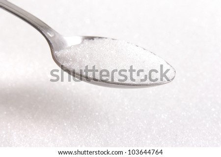 Sugar on a spoon in sugar background
