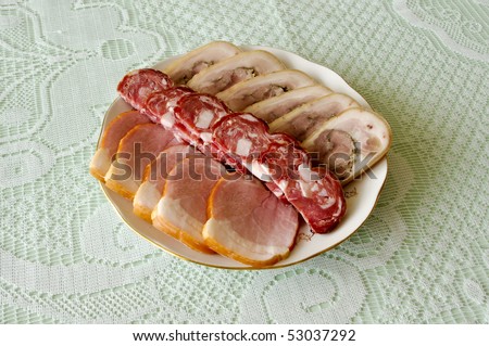 Cutting sausage and cured meat on a celebratory table