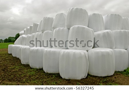 Countryside field with hay bale wrapped in plastic on claudy day