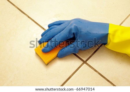 hand wearing a working glove and a sponge