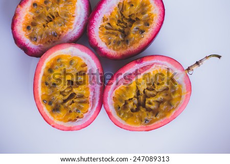 Close up yellow color passion fruit (maracuya) pulp and seed in small ceramic bowl isolated on BROWN board, spoon, spices