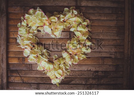 petals flowers hart frame   with a lot of copy space  on brown wood board  background in rustic style for valentine day postcard