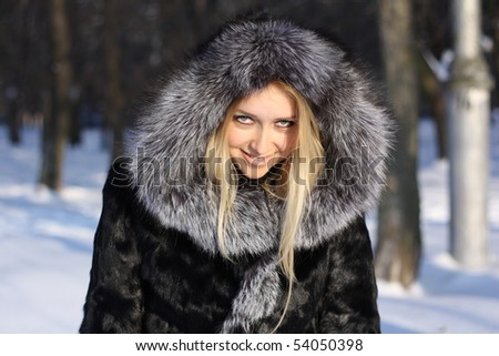 face beauty girl with blonde hair outdoors, in a fur coat