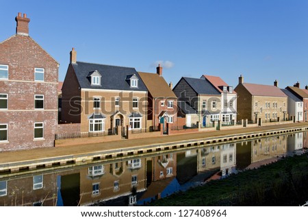 New build houses by a canal in Swindon, Wiltshire, UK. Rather than having houses built in the same style, modern luxury estates utilize a mix of styles and material.