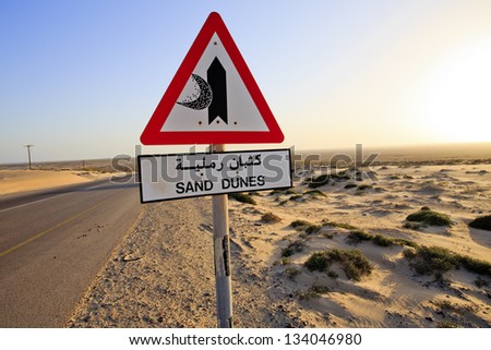 Sand Dunes sign and road in the middle of the desert in Oman on Route 35 - the 'Dunes highway'