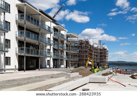 Fornebu, Oslo, Norway, 15 June 2015. Construction workers building luxury apartments on the fjord. The area around the old airport has been converted to high tech offices and new homes