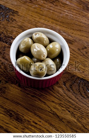 Green olives stuffed with blue cheese in a red and white bowl.