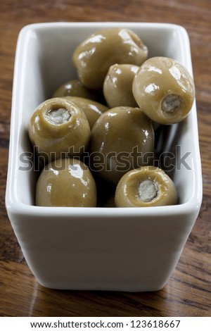 Green olives stuffed with blue cheese in a white bowl.