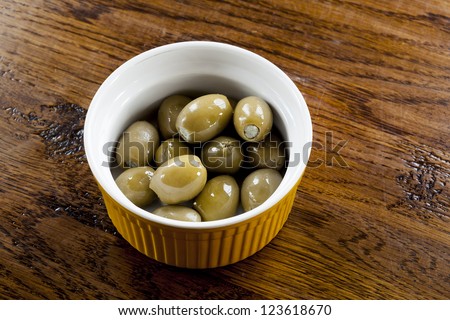 Green olives stuffed with blue cheese in a yellow bowl.