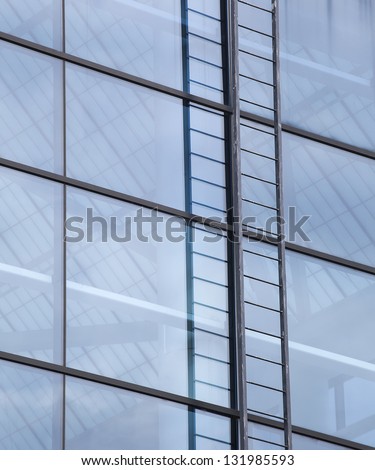 Abstract photo of a contemporary building with blue windows and ladder.