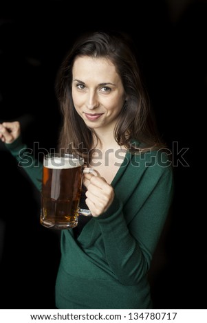 Beautiful young woman with brown hair and eyes holding a mug of beer.