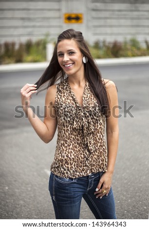 Beautiful young woman with brown hair and eyes in a leopard skin top.
