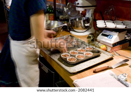 Photo of a baker making chocolate muffins in an organic bakery.