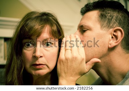 Photo of an attractive man telling a woman a surprising secret. Photo was cross processed.