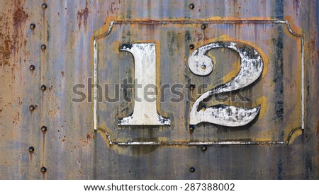 grunge rusty steampunk metal background with faded painted number twelve