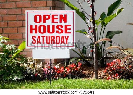 White and red open house sign in front of the small suburban house.