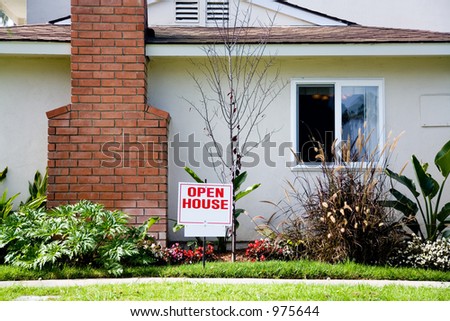 White and red open house sign in front of the small suburban house. There is some additional space for text on the sign.