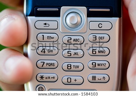 Hand holding mobile phone keypad