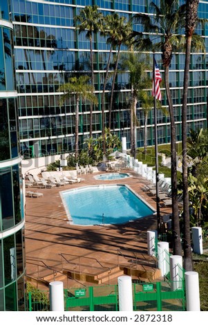 Pool and hot tub in front of the hotel with an American flag.