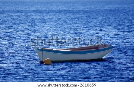 A small wooden boat anchored in the bay