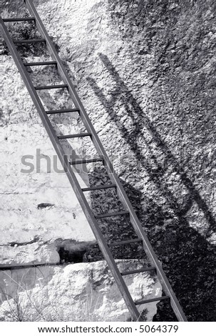 Rusty metal ladder on a stone wall in an old abandoned stone quarry.