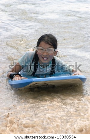 young girl on a boogie board in the ocean