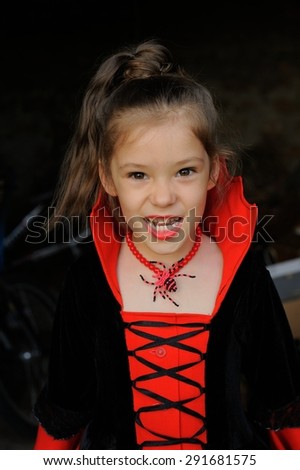 Little Vampire; a little girl in vampire-styled fancy costume posing
