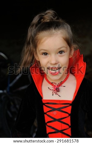 Little Vampire; a little girl in vampire-styled fancy costume posing