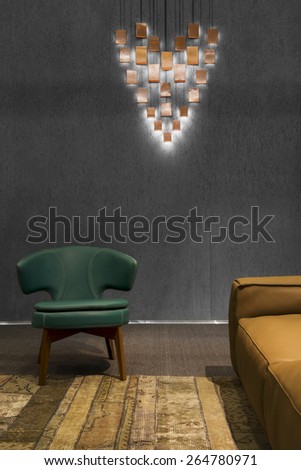 Detail of a dark modern minimalistic living room with brown sofa and blue leather armchair