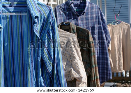 Assorted shirts hanging outside to dry.