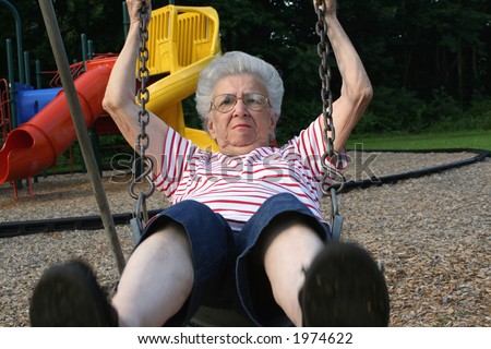 Senior citizen woman on playground swing.