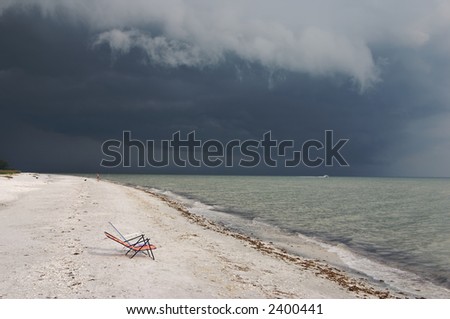 Summer storm approaching - fisherman seems unphased, but there\'s a boat screaming thru the water to get ahead of the storm