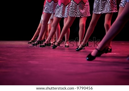 Dancers on stage during a recital in bright costumes. Noise reduction was applied on the floor and the dancers in the background but not the foreground dancers.