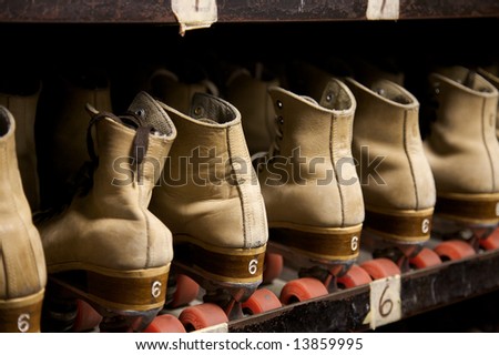 The roller skates are all lined up ready to be worn at the roller rink.